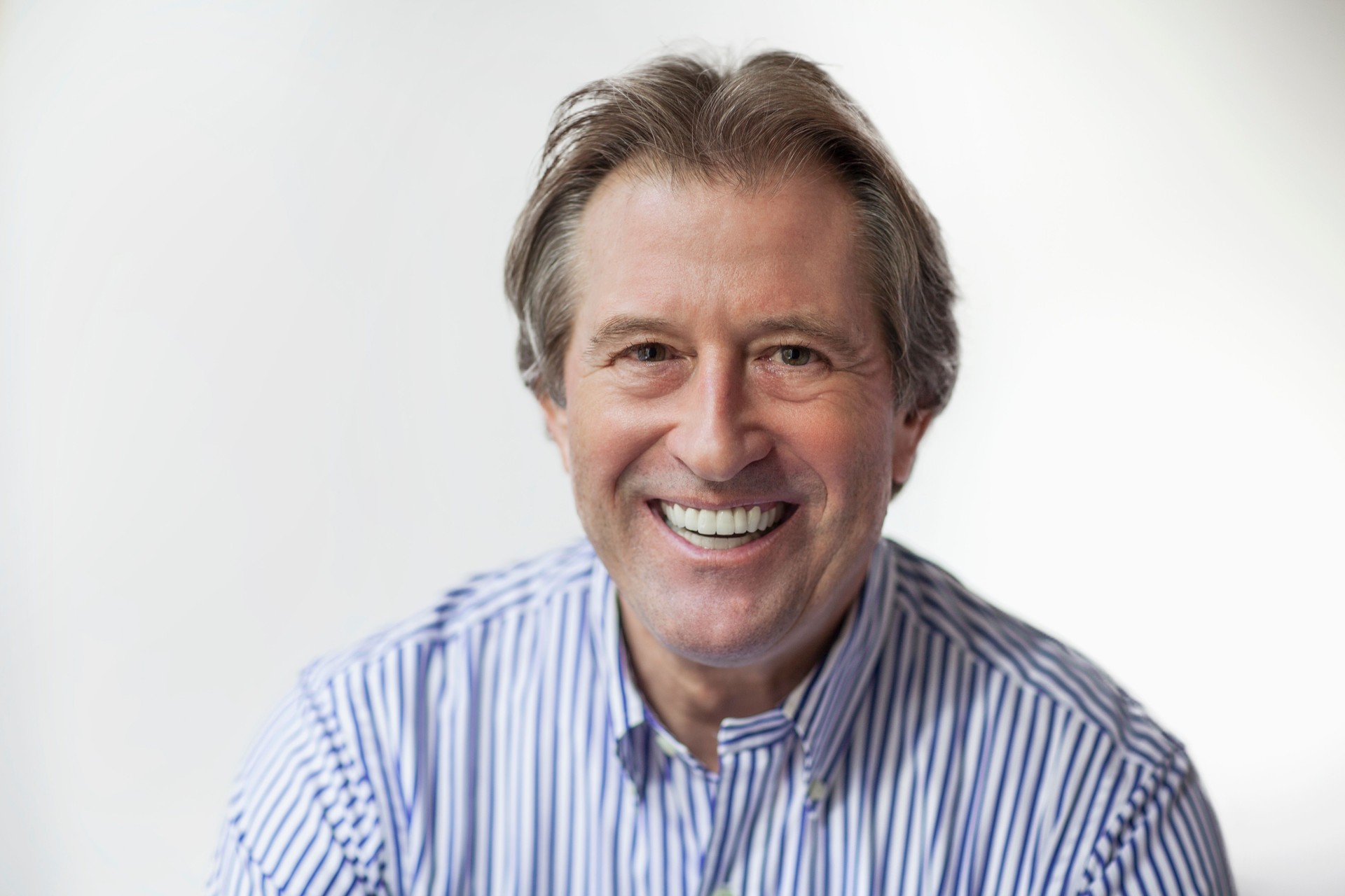 Portrait of mature man looking at camera on white background